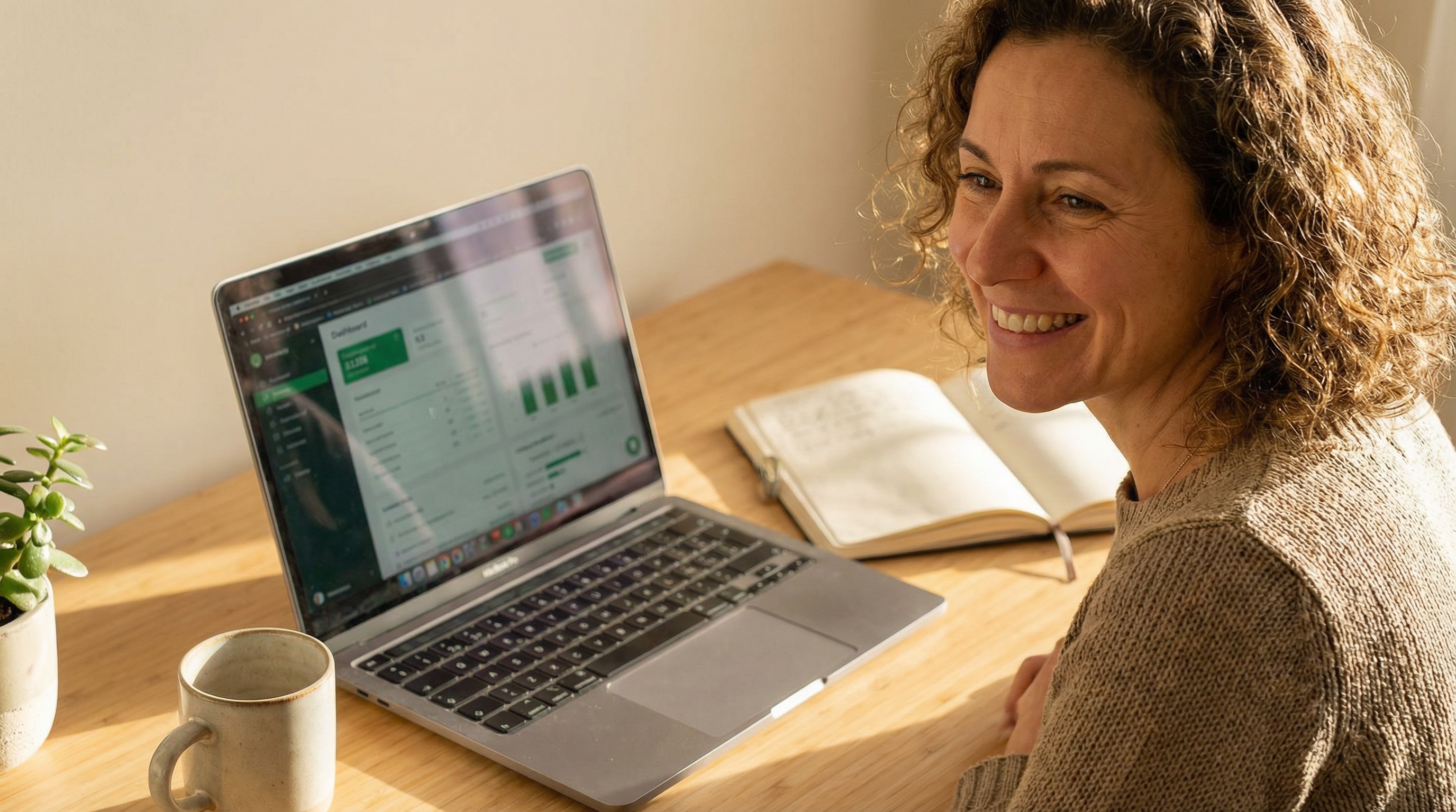 Nutritionist smiling at laptop with green dashboard